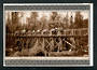 Reproduction of postcard of Timber Milling in the backblocks of the Wellington province. Tking a log to the timber mill at Raeti